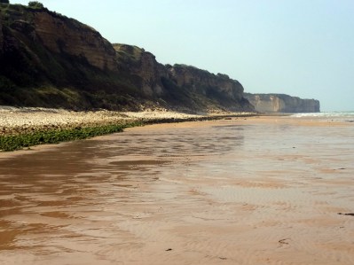 Omaha Beach was the site of some of the most courageous and costly actions by American troops. They had to take the German positions on those cliffs. Many died, but they ultimately succeeded. The movie "Saving Private Ryan" begins on this beach.