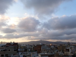 The ever-changing sky over the distant mountains offered a serene contrast to the teeming life of the city.